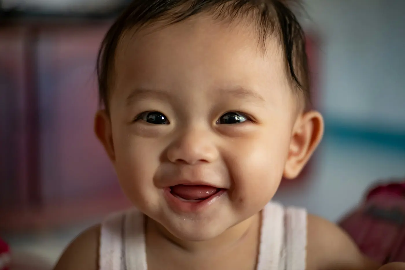 Bayi tersenyum lebar ke arah kamera