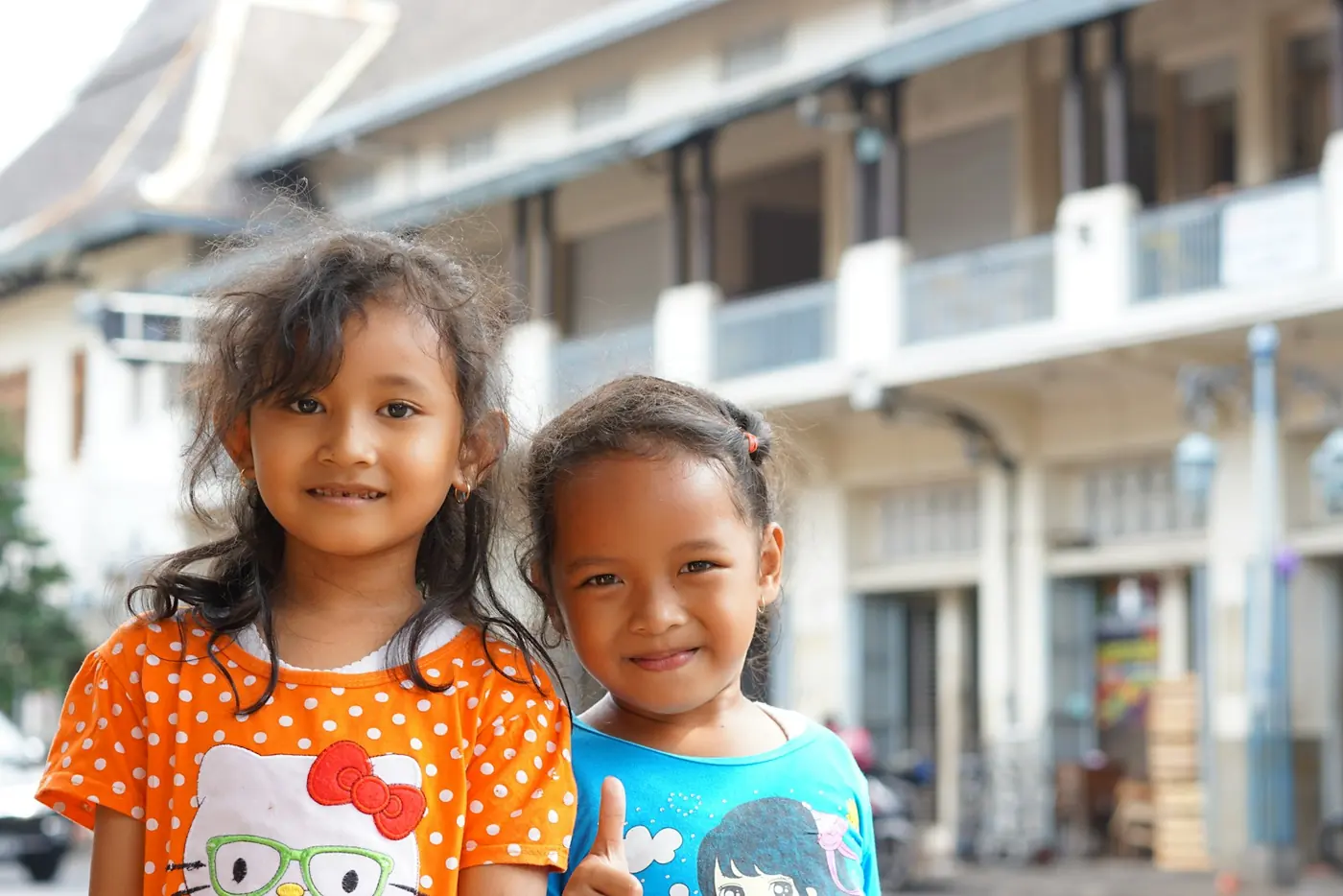 Dua anak perempuan tersenyum berdampingan